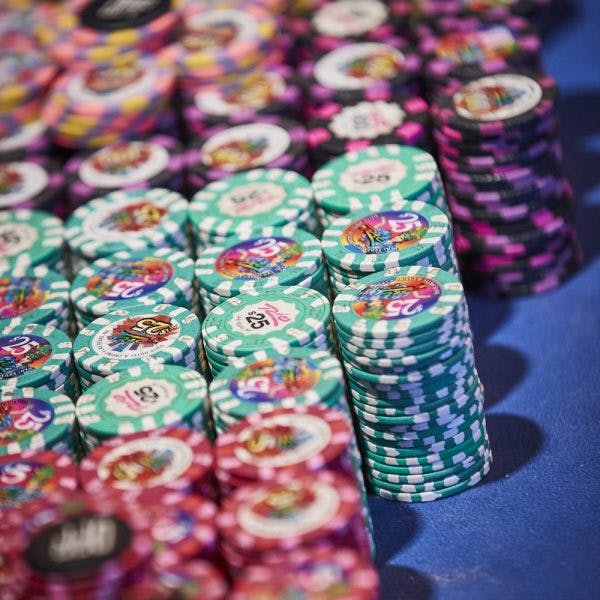 Stacks of various table games chips of different monetary value on a blue felt table inside Rio Hotel & Casino Las Vegas