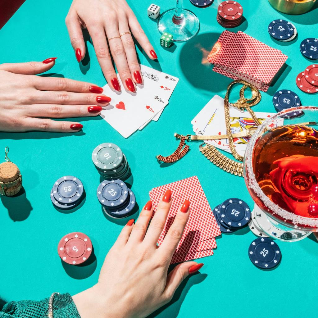 Stylish female hands playing cards on poker table.