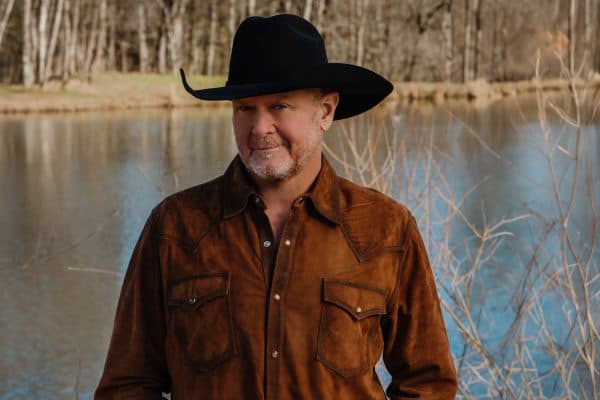 Tracy Lawrence standing next to a lake
