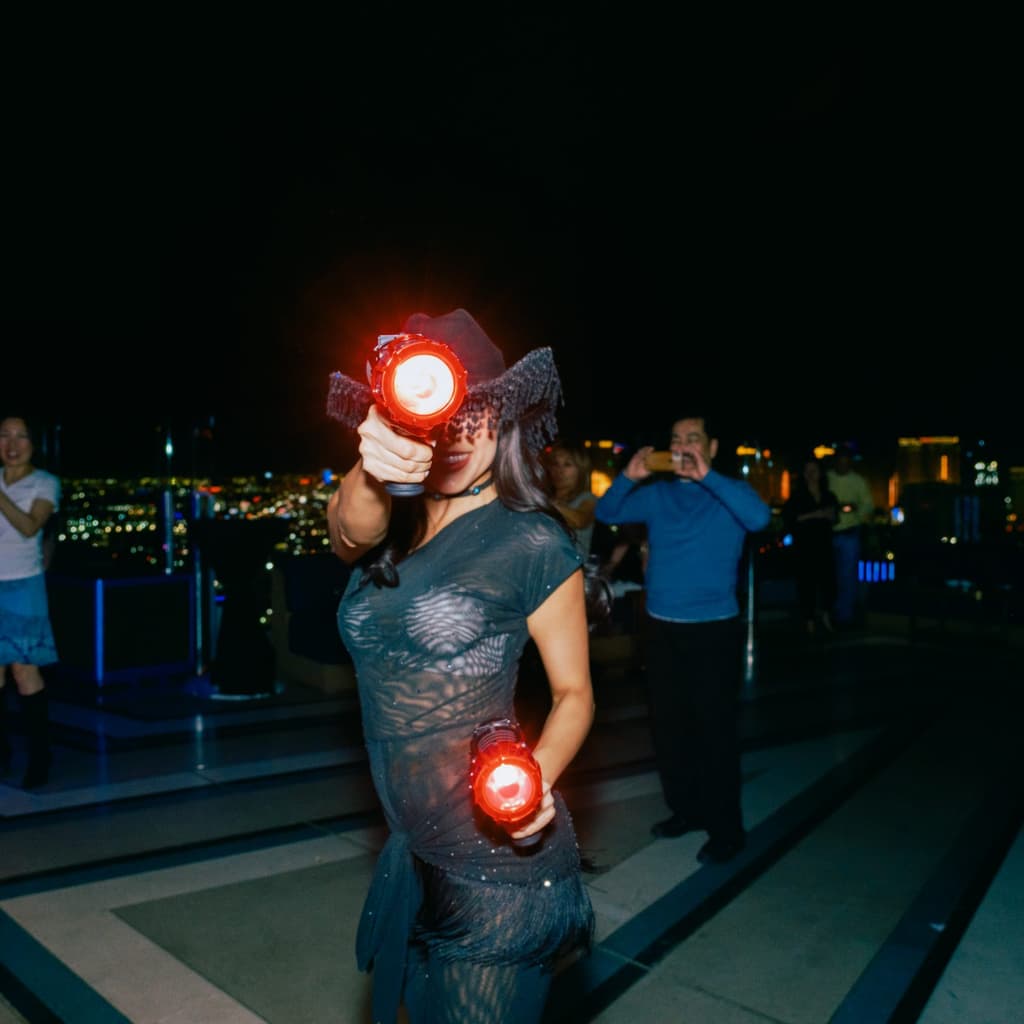 Woman in a costume blinking a red light back at the camera